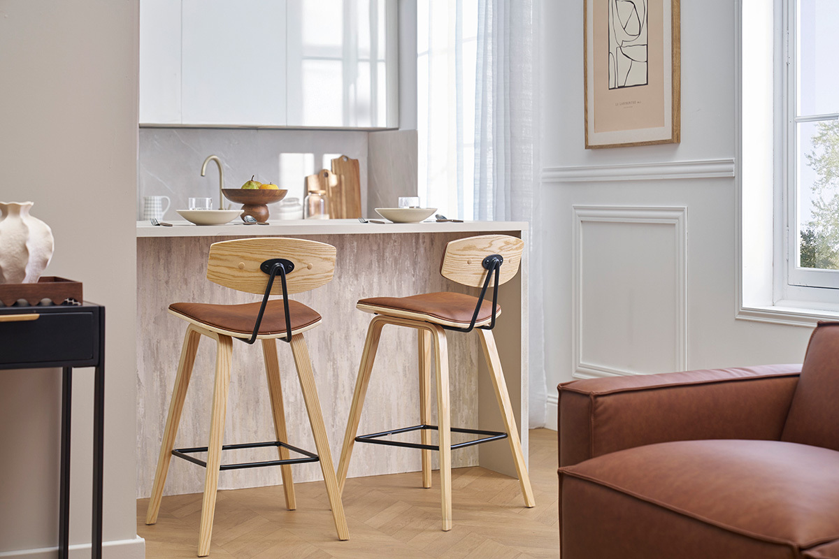Deux tabourets de bar marron et bois clair devant un comptoir dans une cuisine moderne.