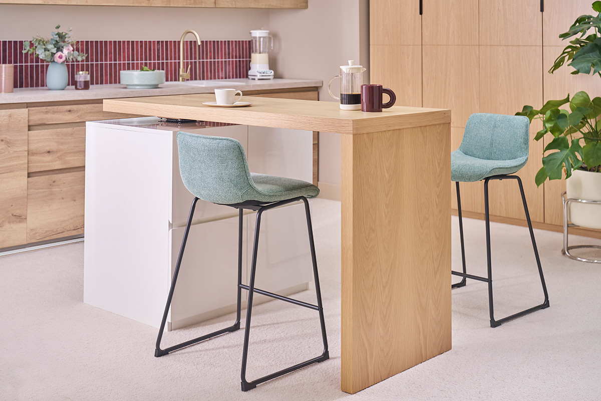 Tabourets de bar en tissu bleu-vert avec pieds en m�tal noir, dans une cuisine moderne.