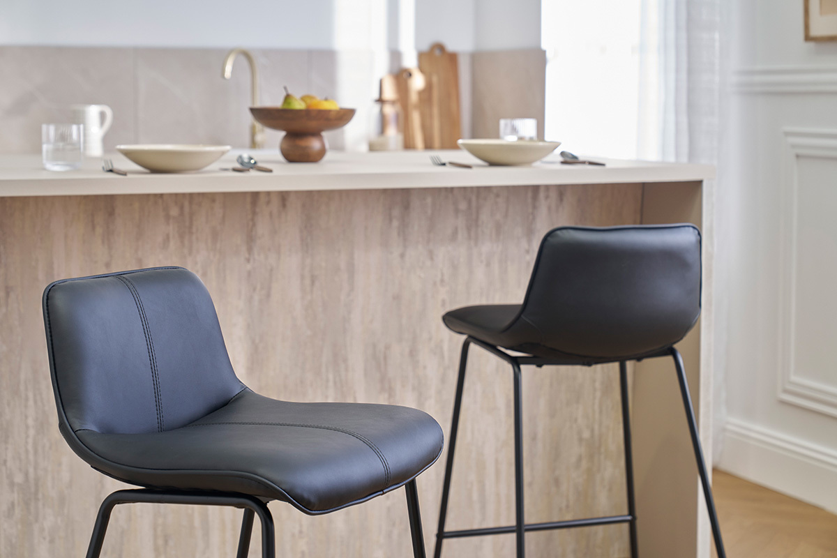 Deux tabourets de bar noirs en mtal devant un comptoir de cuisine.