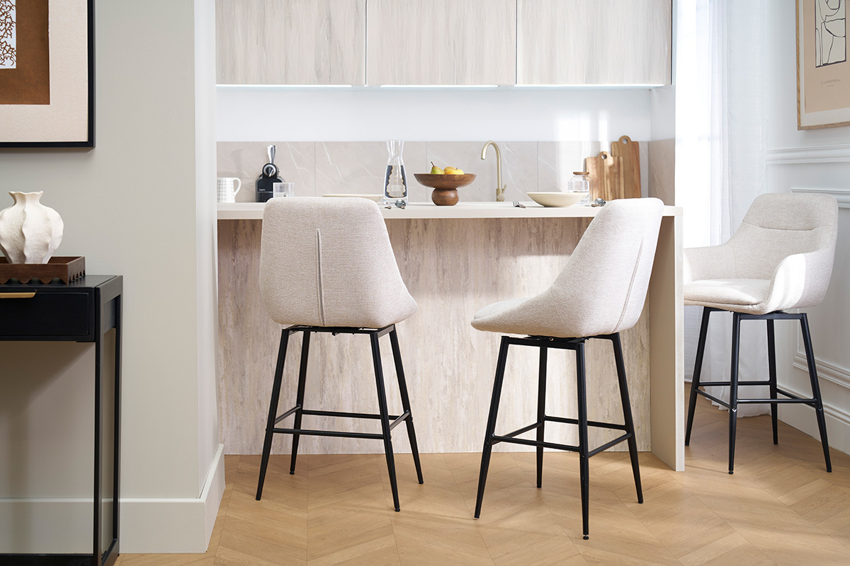 Tabourets de bar beige effet velours et mtal devant un comptoir.