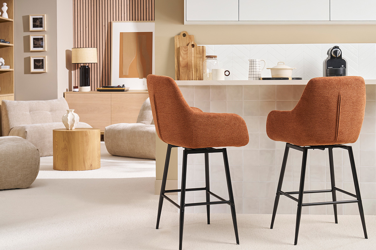 Deux tabourets de bar en tissu terre brle et mtal noir devant un comptoir.