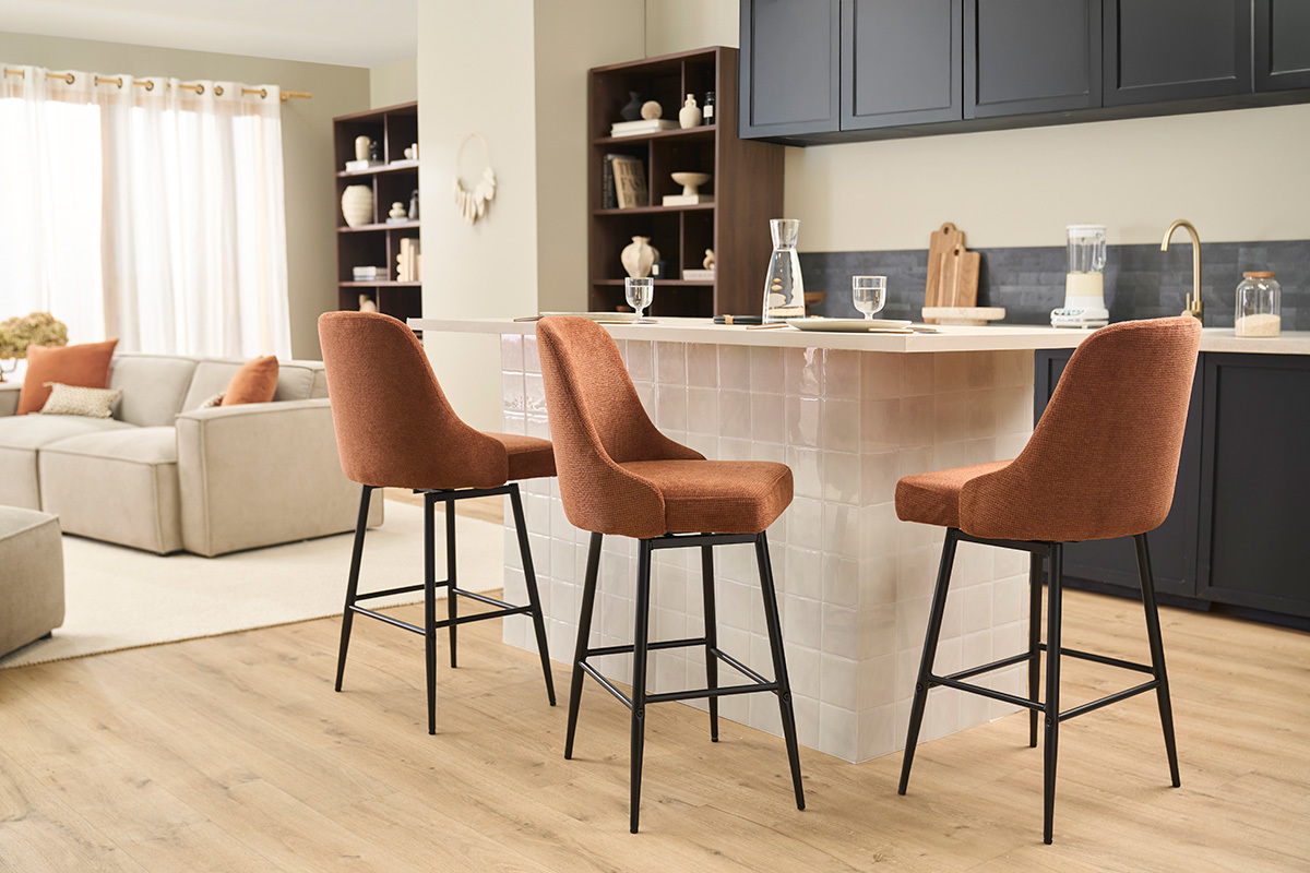 Tabourets HASTA en tissu terre br�l�e et m�tal noir autour d'un �lot de cuisine.