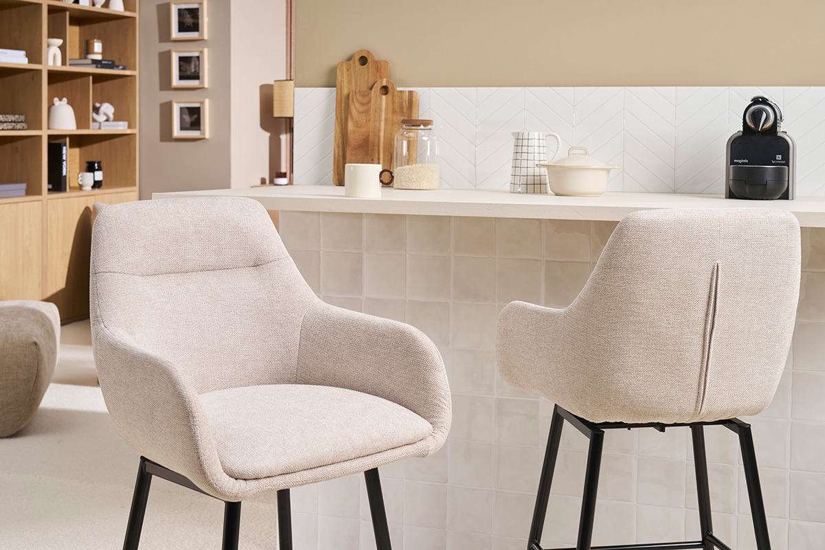 Tabourets de bar en tissu beige et m�tal noir devant un comptoir dans une cuisine.