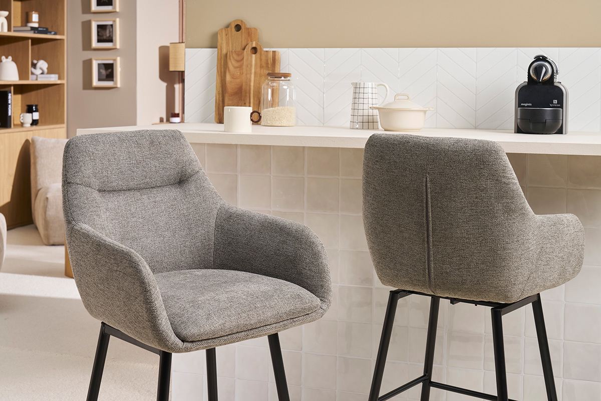 Deux chaises de bar grises en tissu vues de profil et de dos devant un comptoir.