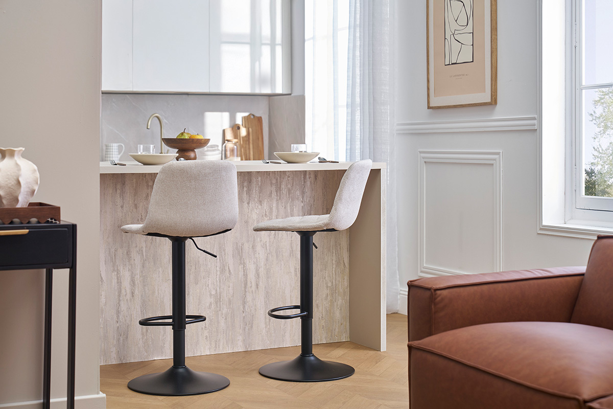 Deux tabourets de bar rglables beige et noir, de profil, devant un comptoir.