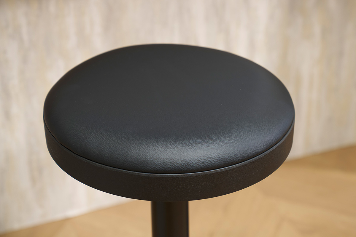 Assise de tabouret de bar noir en polyurthane vue de dessus.