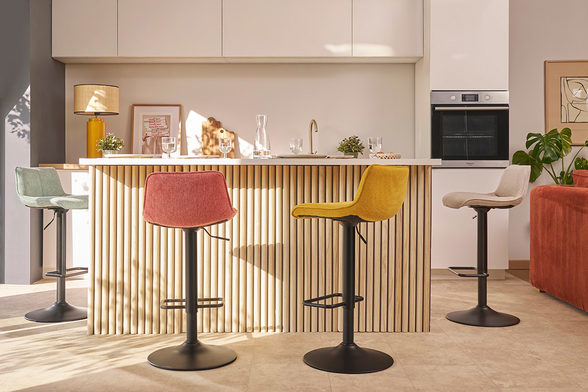 Cuisine avec des tabourets de bar en tissu effet velours et m�tal noir autour d'un comptoir.