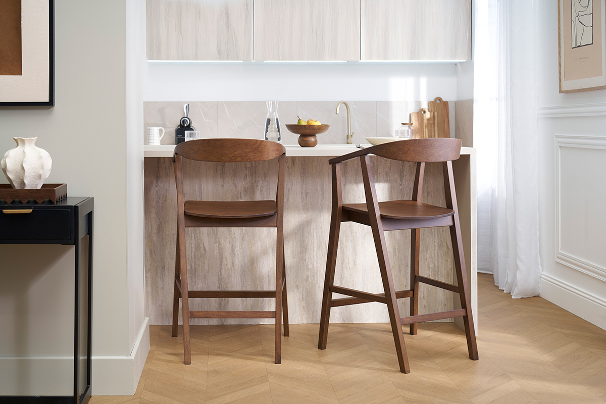 Deux tabourets de bar scandinaves en bois fonc BAHIA devant un lot de cuisine.