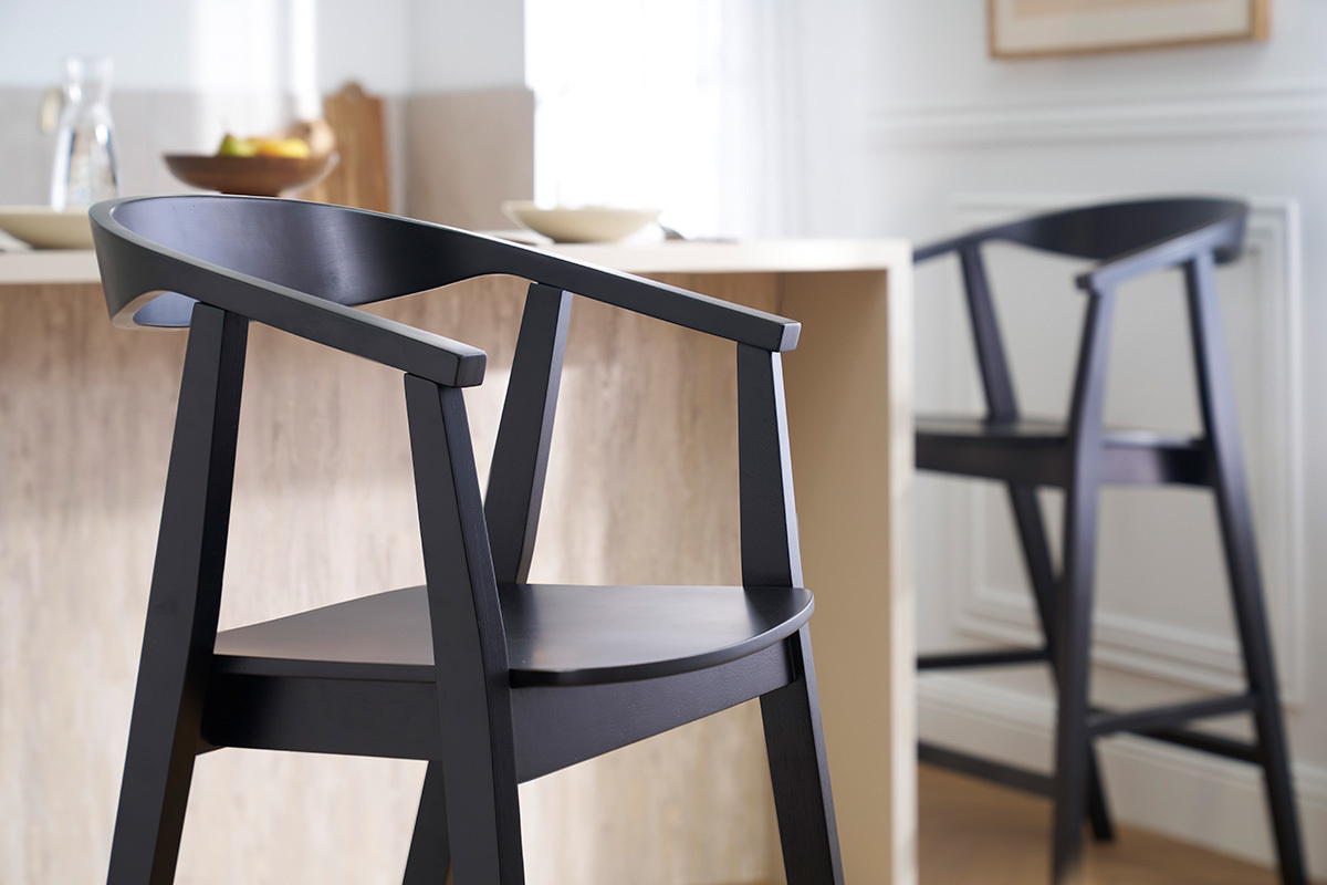 Deux tabourets de bar noirs en bois BAHIA prs d'un comptoir, vue zoome.