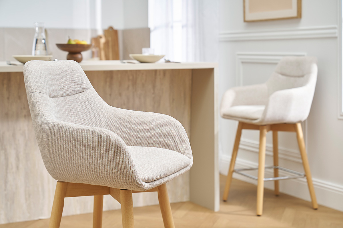 Tabourets de bar scandinaves beiges en tissu et bois, vue d'angle.