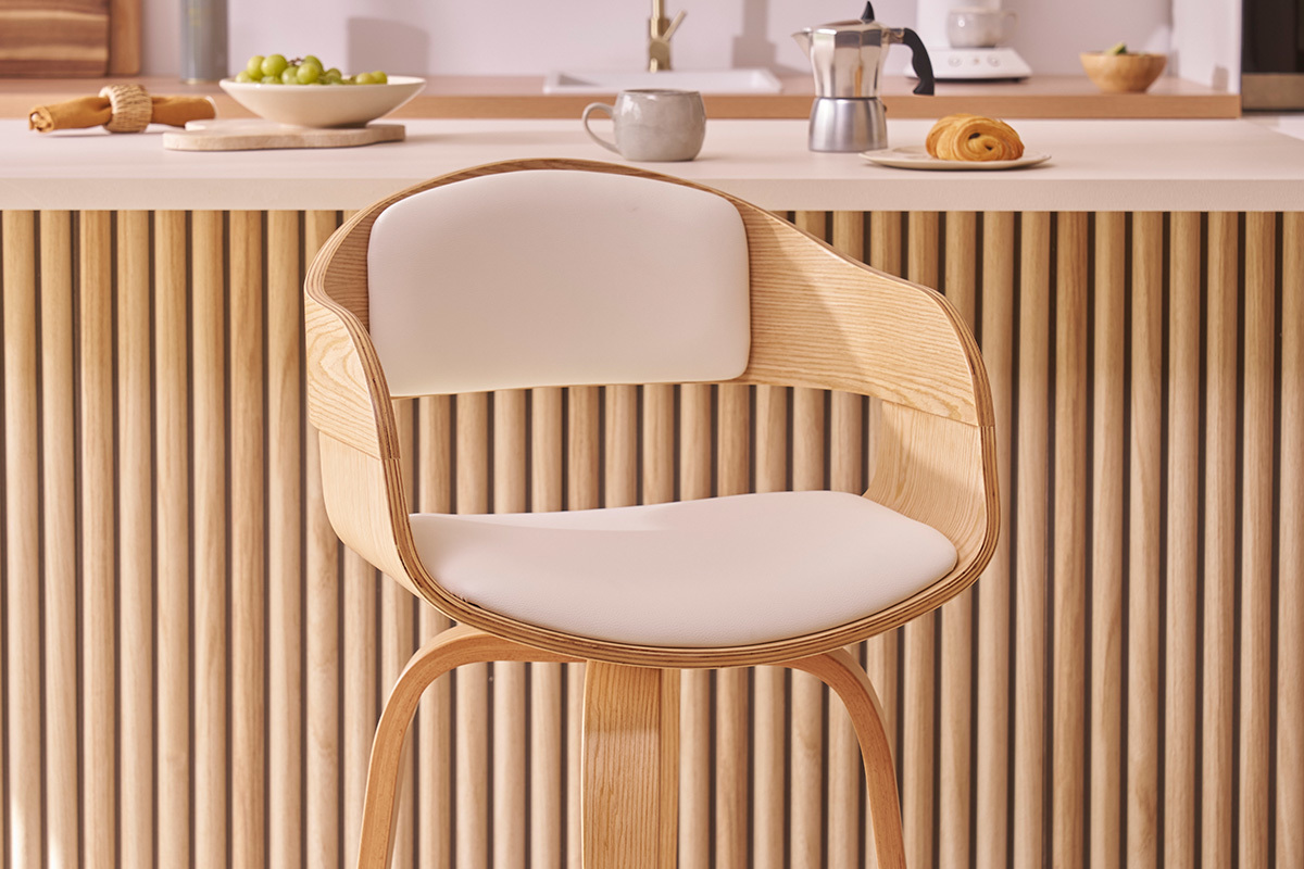 Tabouret de bar scandinave en bois clair avec si�ge en polyur�thane blanc devant un comptoir de cuisine.