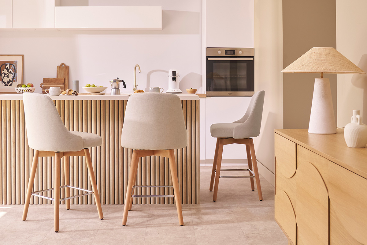 Tabourets de bar scandinaves pivotants en tissu beige, dans une cuisine moderne.
