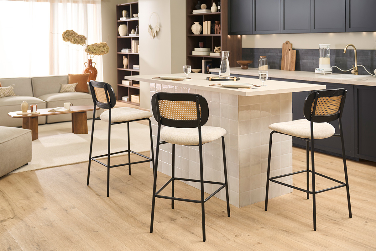 Tabourets design MIRANDA en tissu beige et rotin, entourant un �lot de cuisine dans une pi�ce moderne.