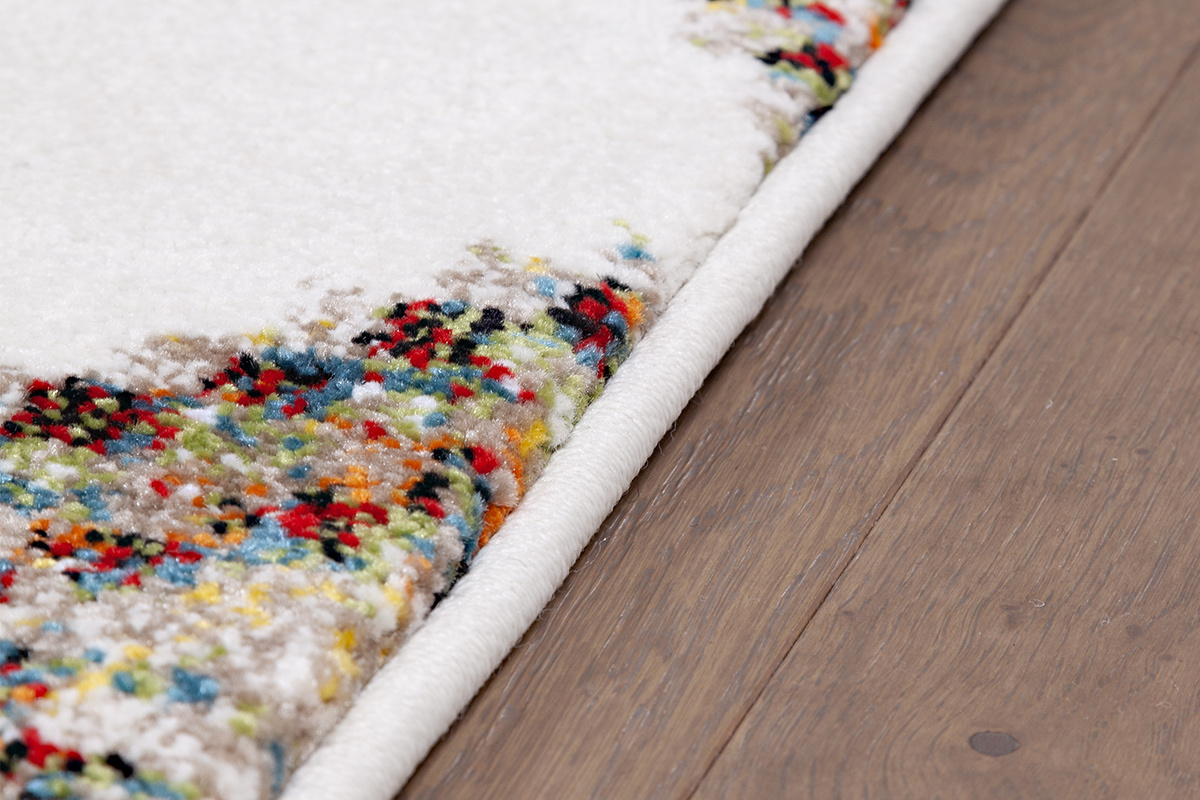 Tapis � motifs color�s, vue en angle sur un sol en bois.