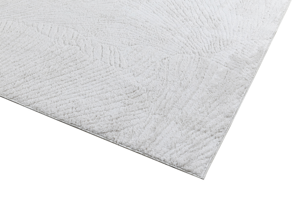 Tapis rectangulaire ivoire � motifs, vue en d�tail avec texture sur le bord.