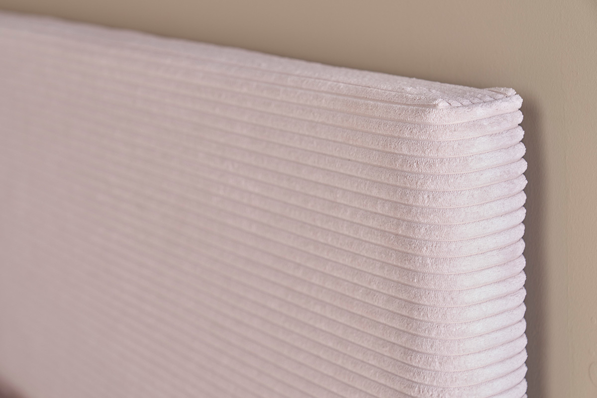 Vue en angle de la tte de lit YOLANDA en velours ctel beige.